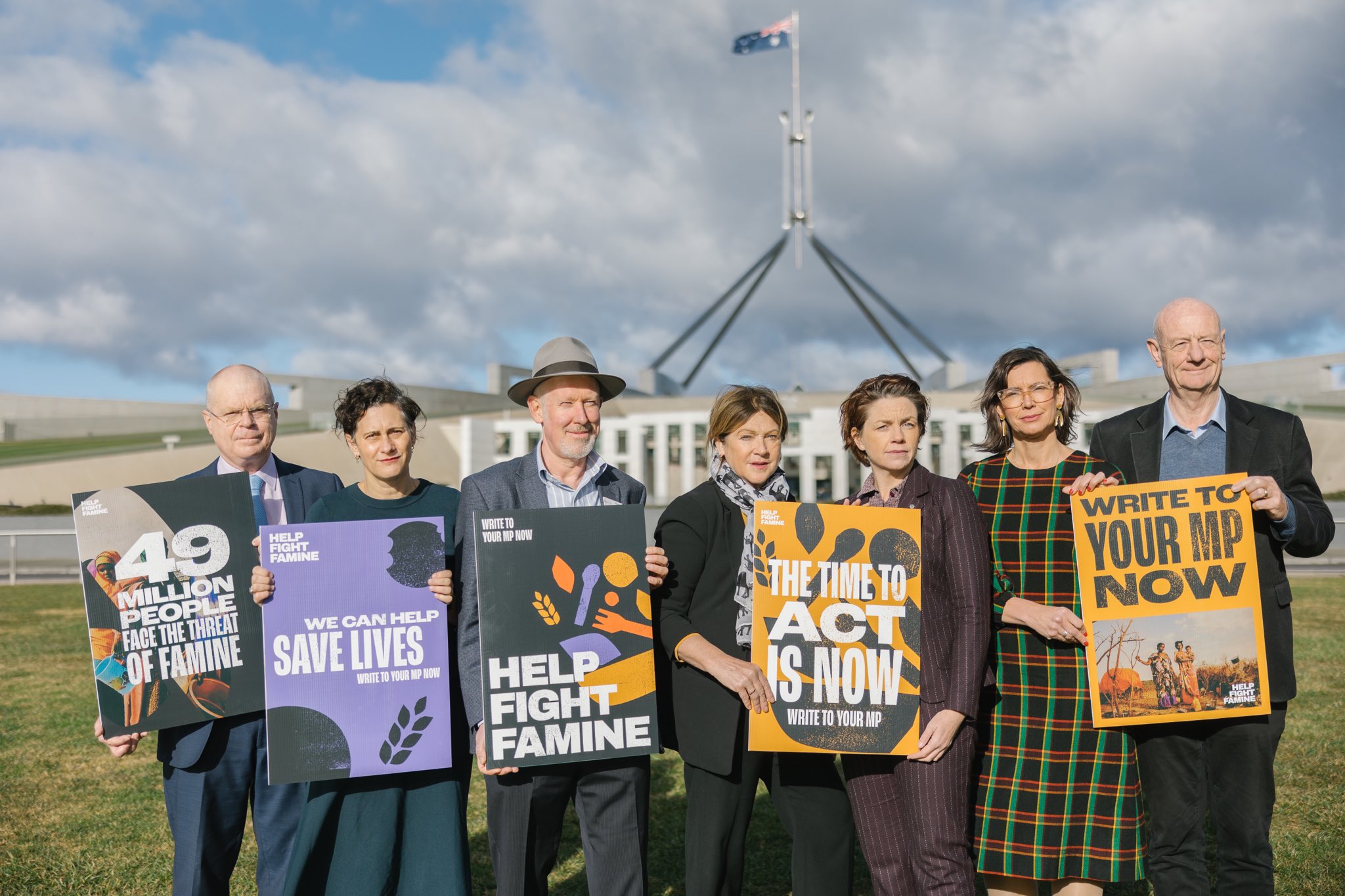 CEOs of aid agencies stand outside of Parliament house with Help Fight Famine campaign posters