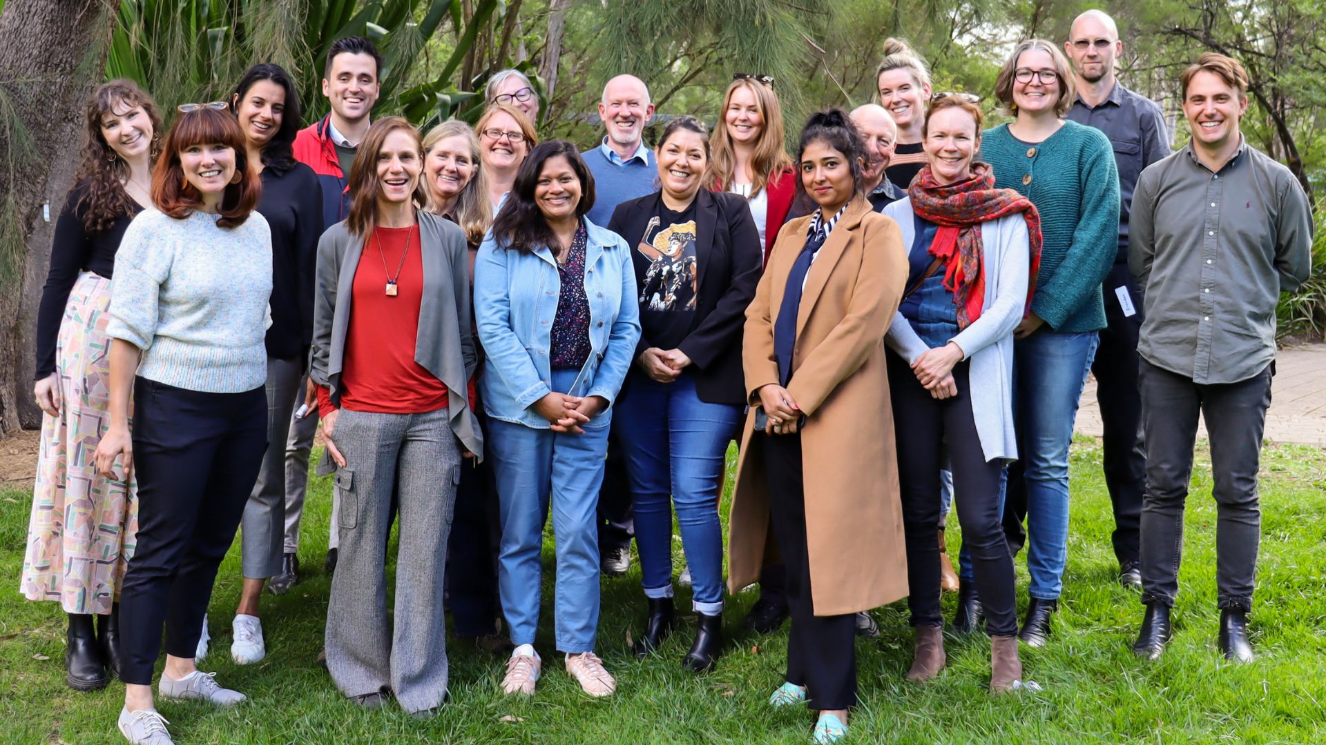 ACFID Staff smile in a grass outdoor area.