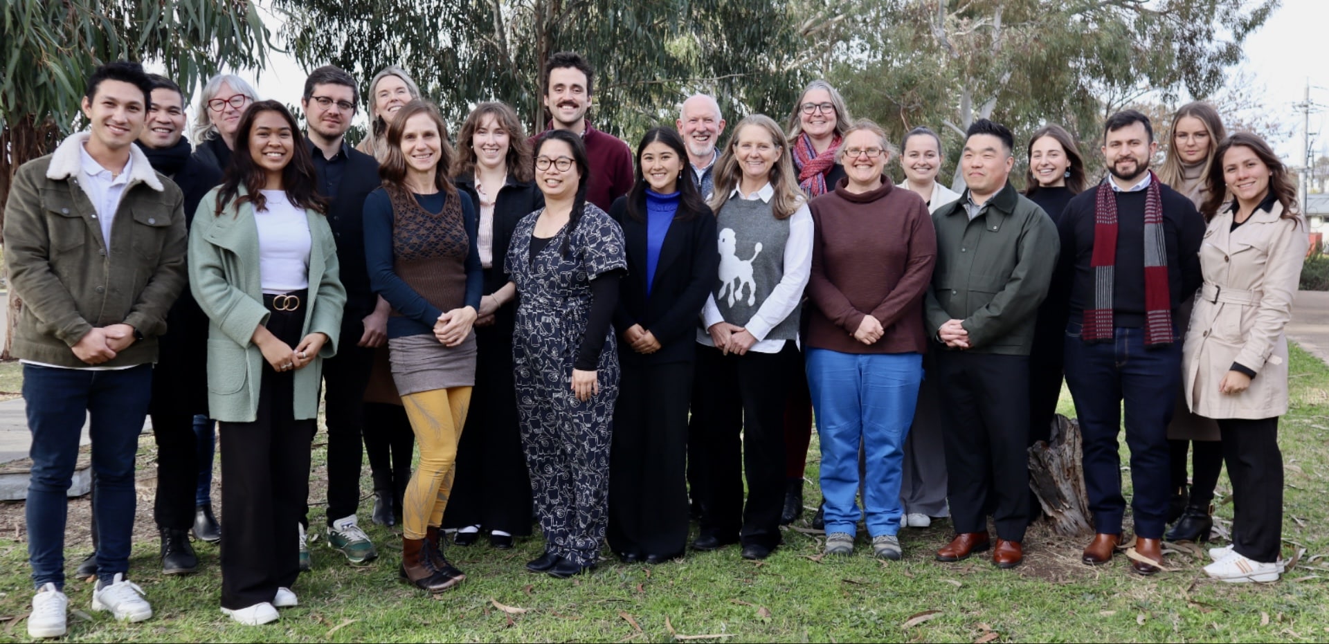 ACFID Staff smile in a grass outdoor area.